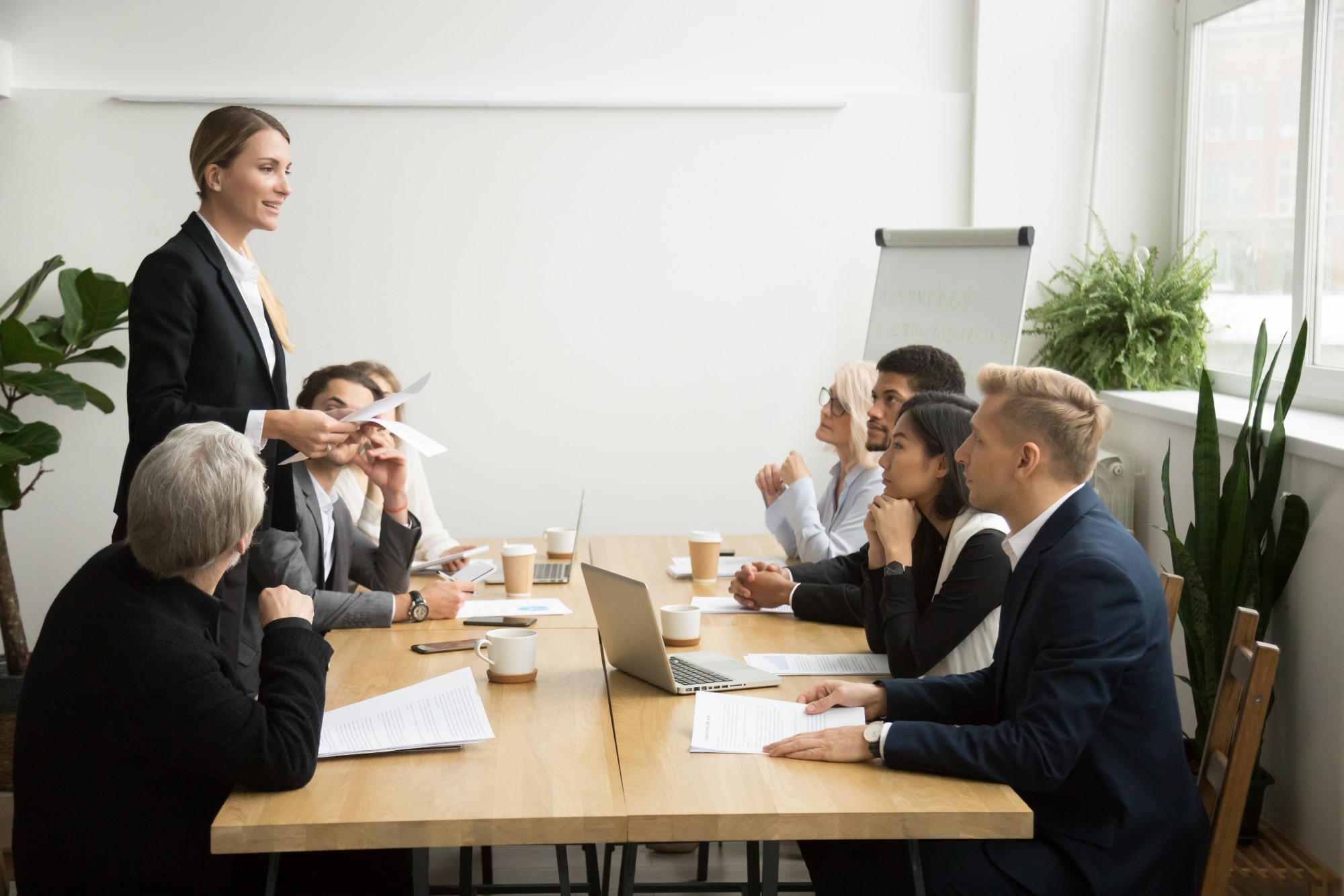 Ejecutiva dirigiendo una reunión de trabajo ante un comité profesional